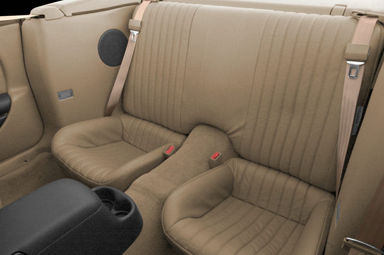 Rear seat with tan upholstery and integrated seatbelts.