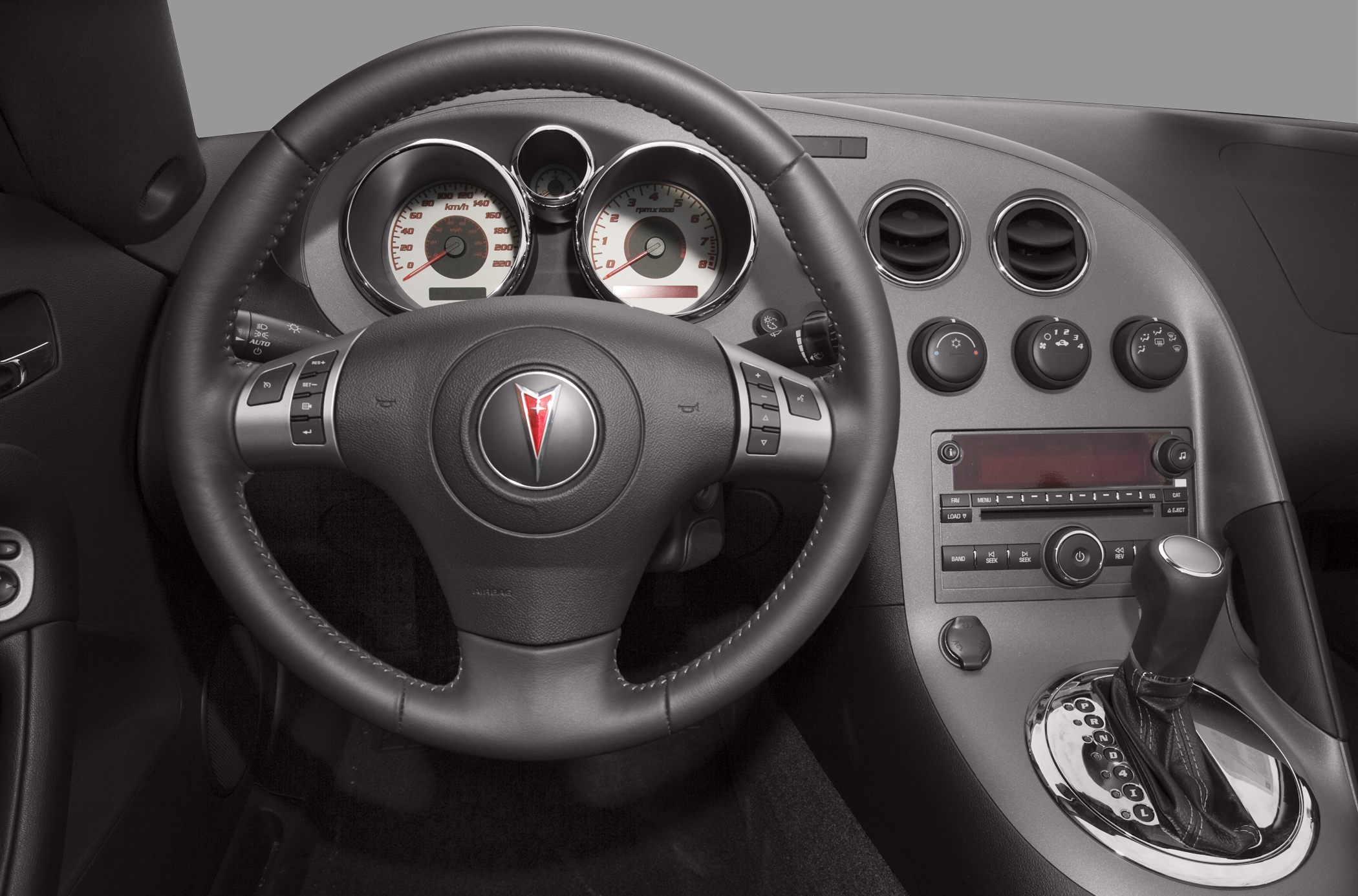 Dashboard, instrument cluster, steering wheel, gear shifter, and climate controls