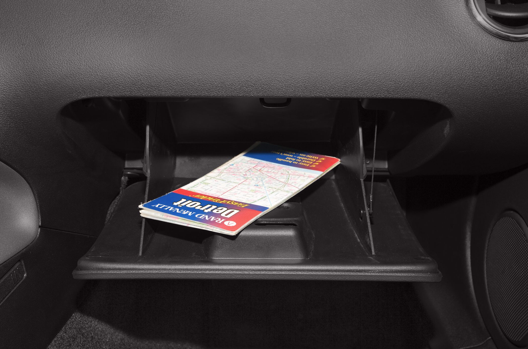 Open glove compartment with map inside in a car interior