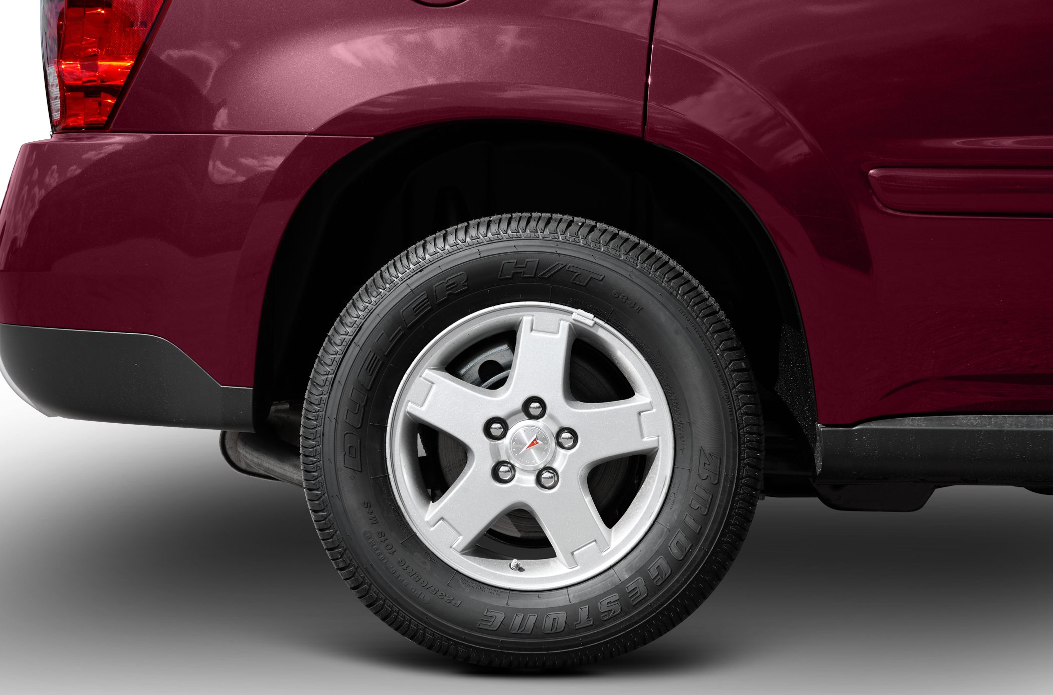 Alloy wheel and rear taillight close-up on burgundy vehicle