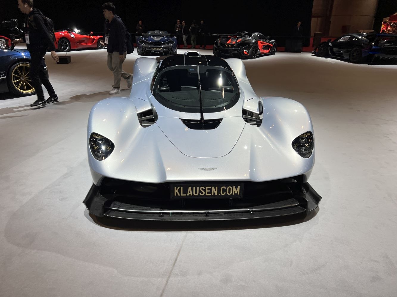 Futuristic aerodynamic sports prototype front view with central cockpit and aggressive splitter