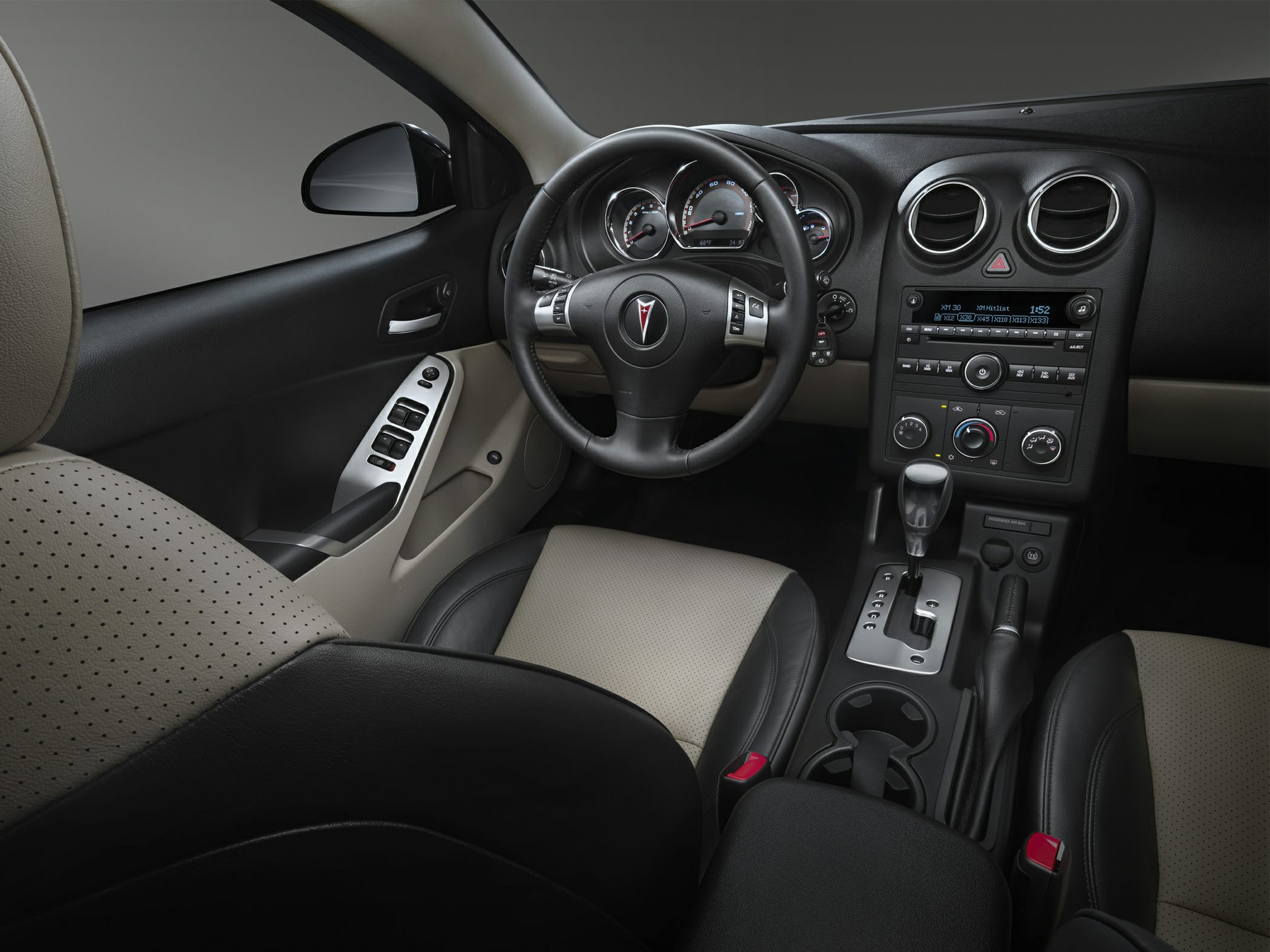 Dashboard, steering wheel, center console, and seats in black and beige upholstery