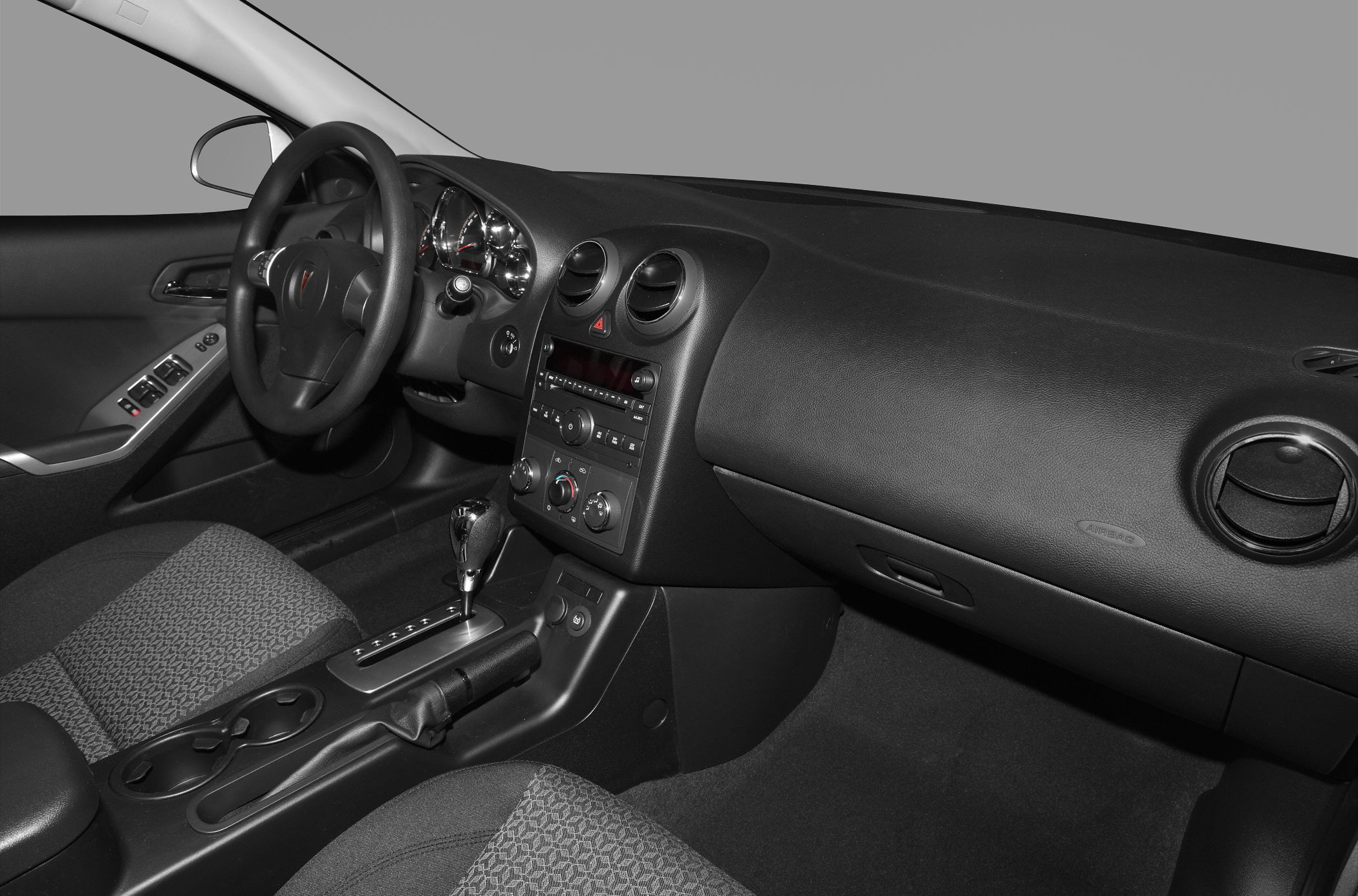 Car interior with dashboard, steering wheel, and automatic gear shifter