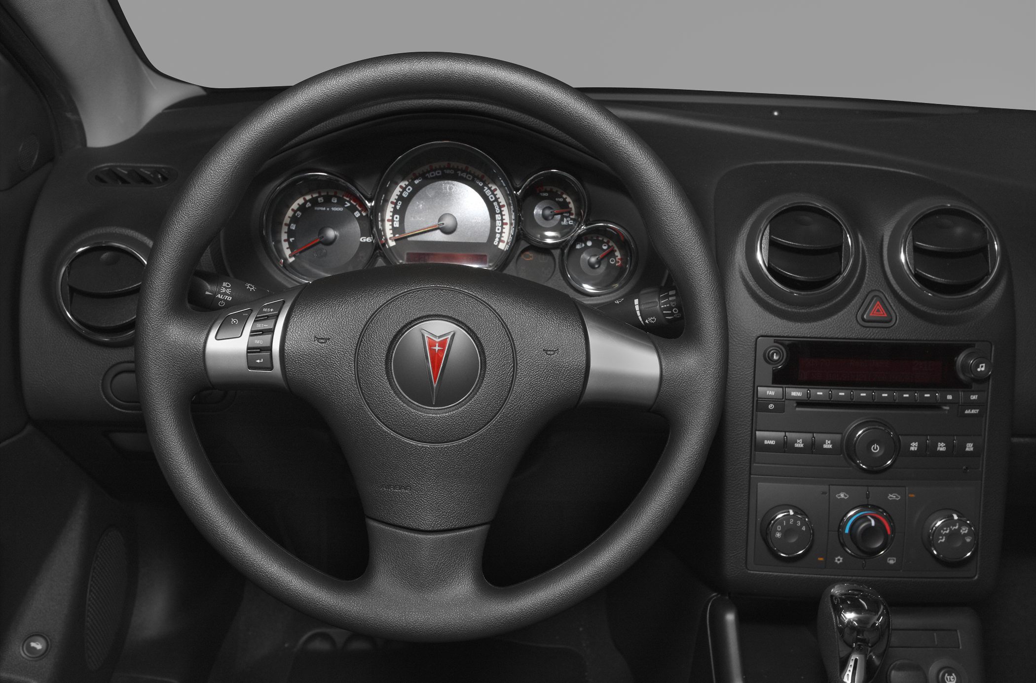 Steering wheel with controls and dashboard instrument cluster.