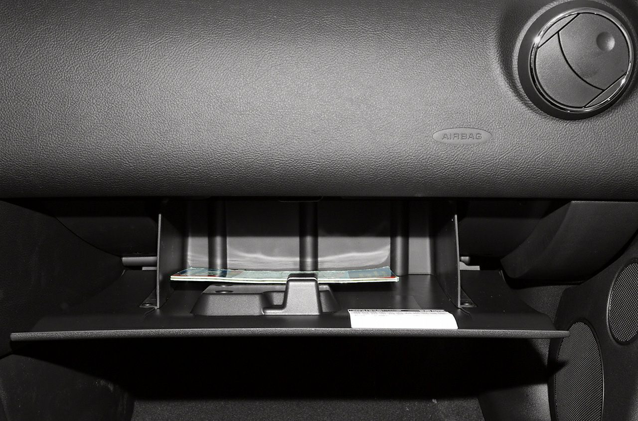 Open glove compartment with textured dashboard and air vent