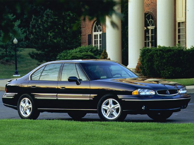 Black four-door sedan with alloy wheels shown from front side view