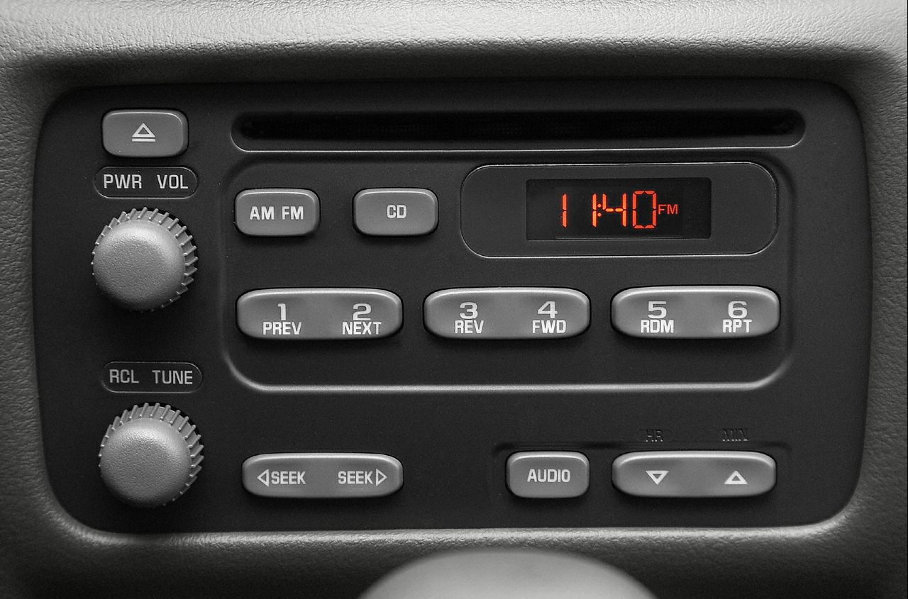 Car radio console with AM/FM, CD, and preset buttons.