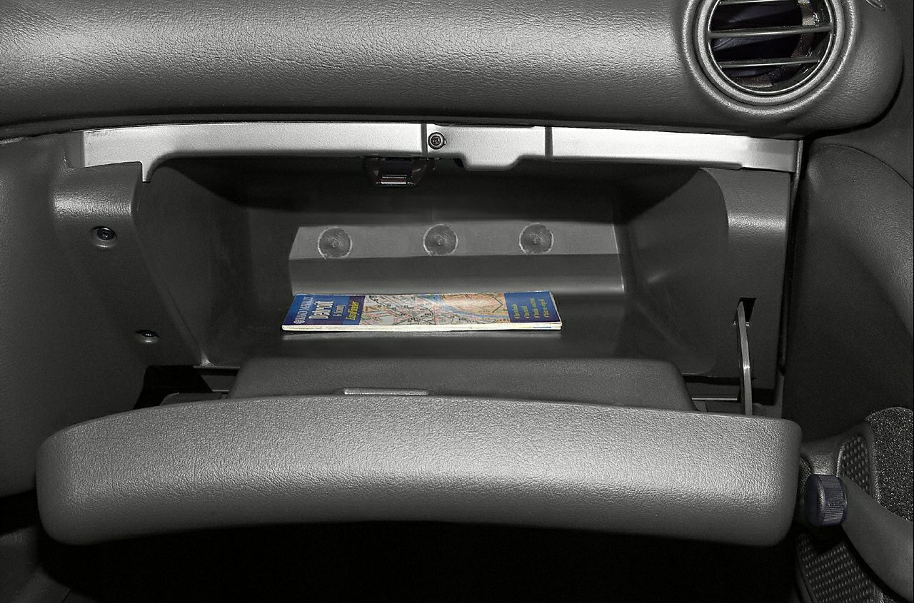 Open glove box compartment with booklet inside