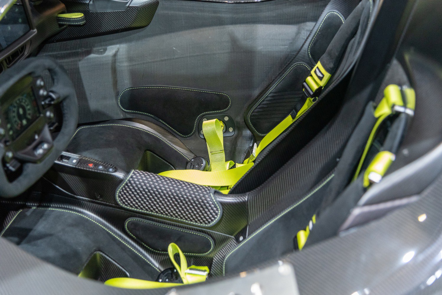 Carbon fiber racing seats with neon-yellow harnesses.