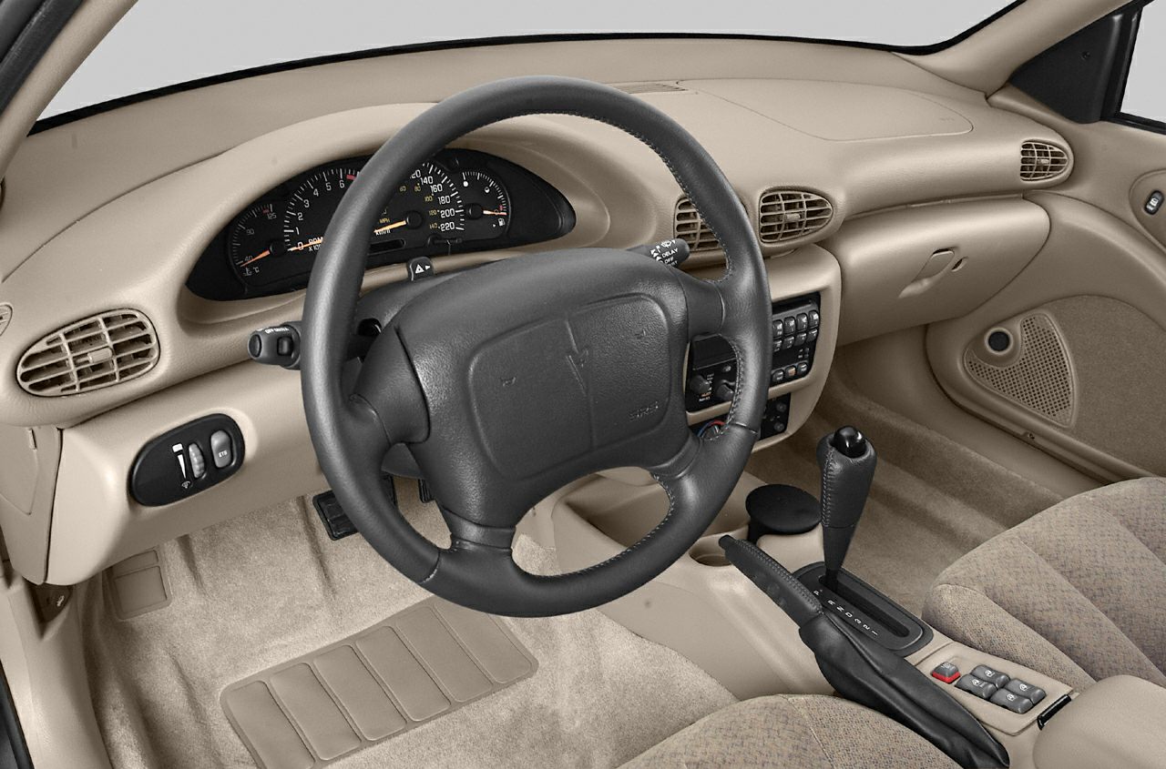 Beige dashboard with steering wheel, gauge cluster, and automatic gear shifter