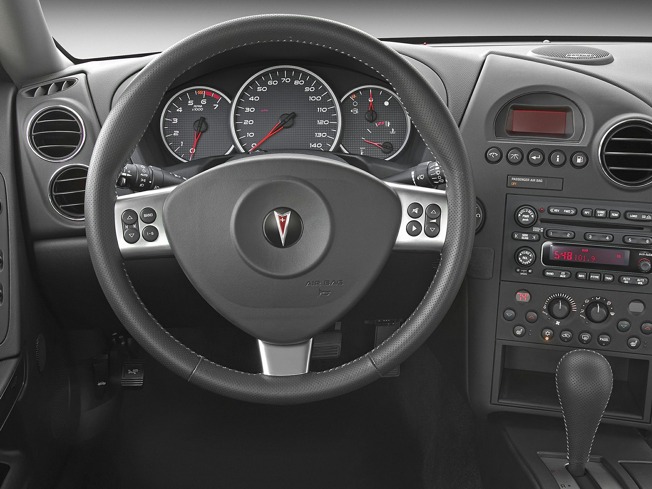 Steering wheel with controls and dashboard instrument cluster in car interior