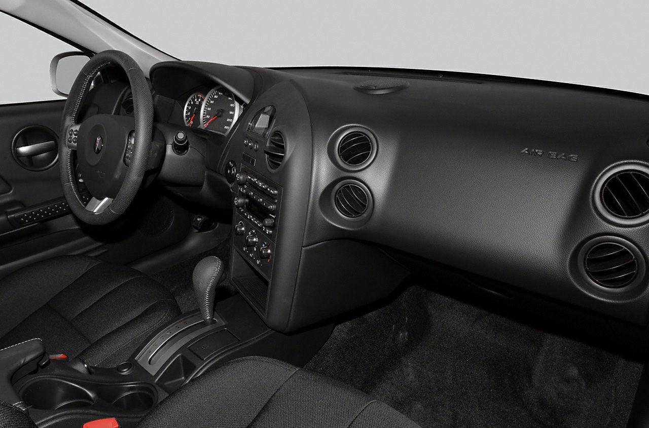 Black dashboard with air vents, steering wheel, and center console gear shift