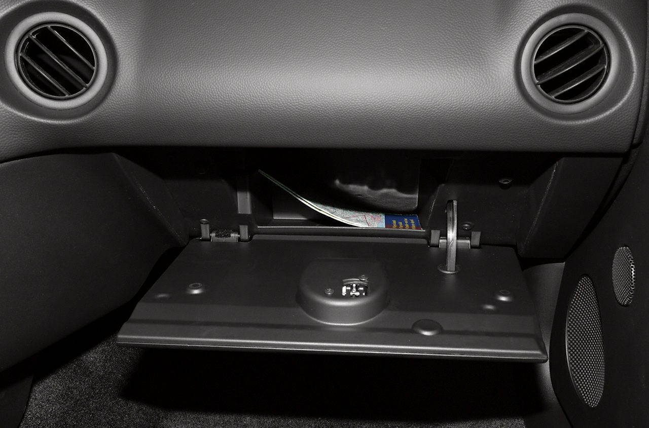 Glove compartment with detailed open storage space and interior panel.