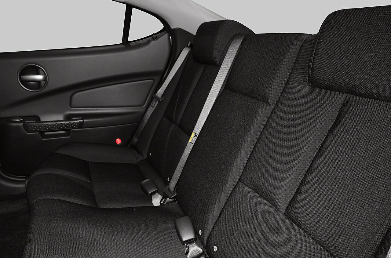 Rear seat fabric upholstery with integrated seat belts and door panel.