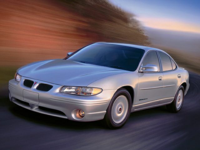 Front side view of silver sedan on curving road