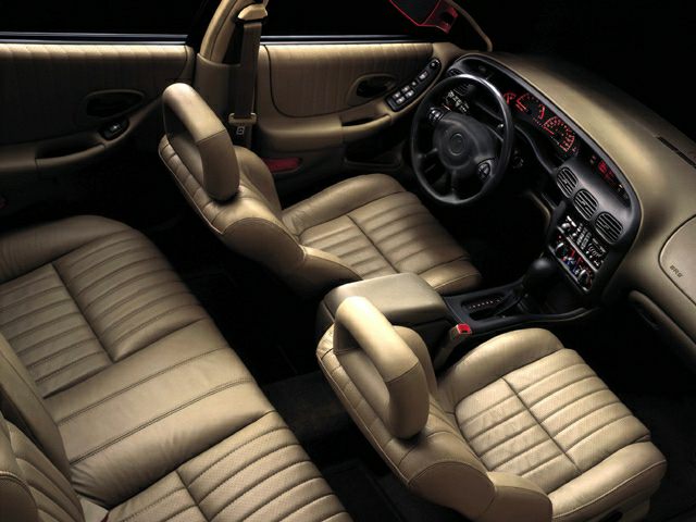 Luxurious beige leather seats and classic dashboard inside a 1997 car.