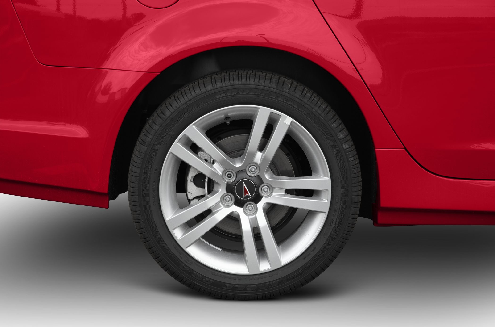 Close-up of alloy wheel and rear fender with red paint