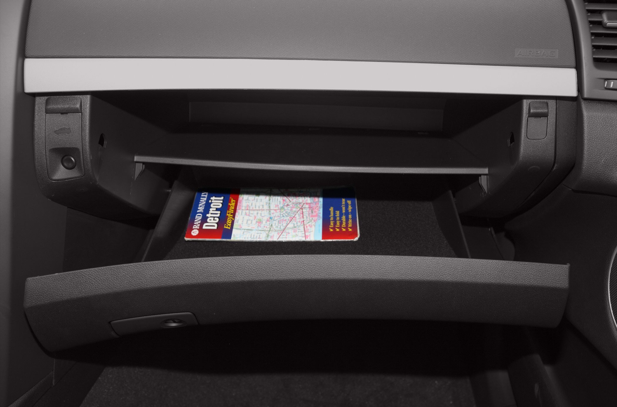 Opened glove box with car map inside