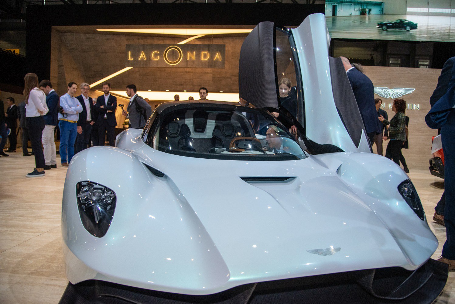 Front view of a white hypercar with open butterfly doors
