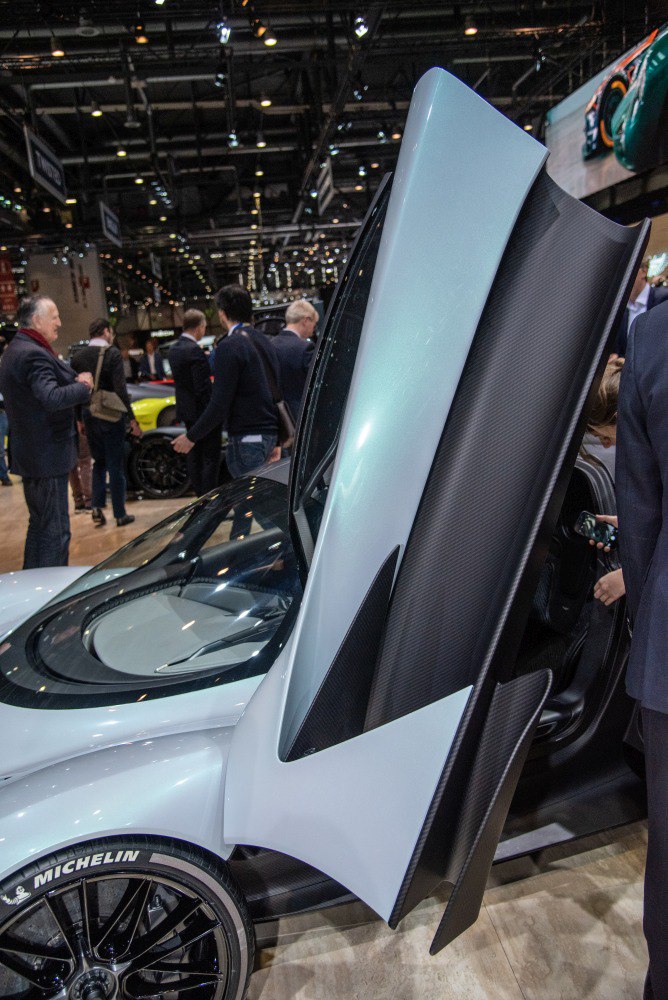 Butterfly door open showing carbon fiber panel and Michelin tire