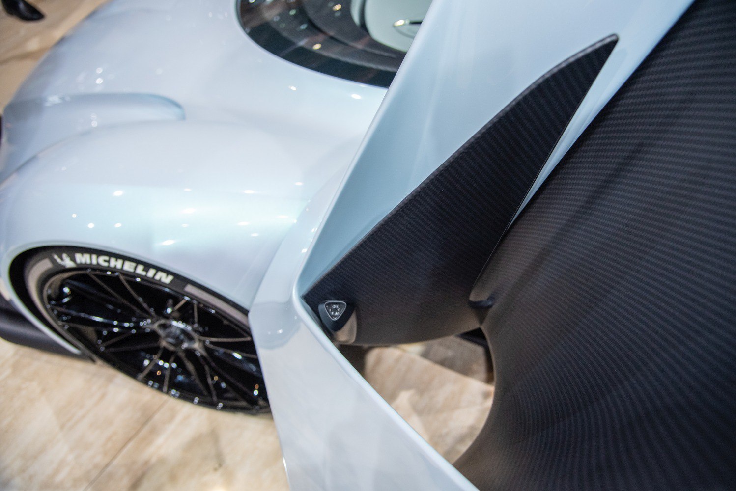 Carbon fiber rear wing and black Michelin wheel close-up