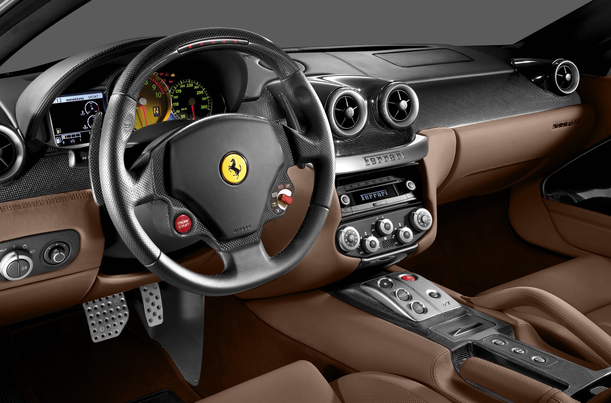 Dashboard and steering wheel with carbon fiber trim and analog gauges