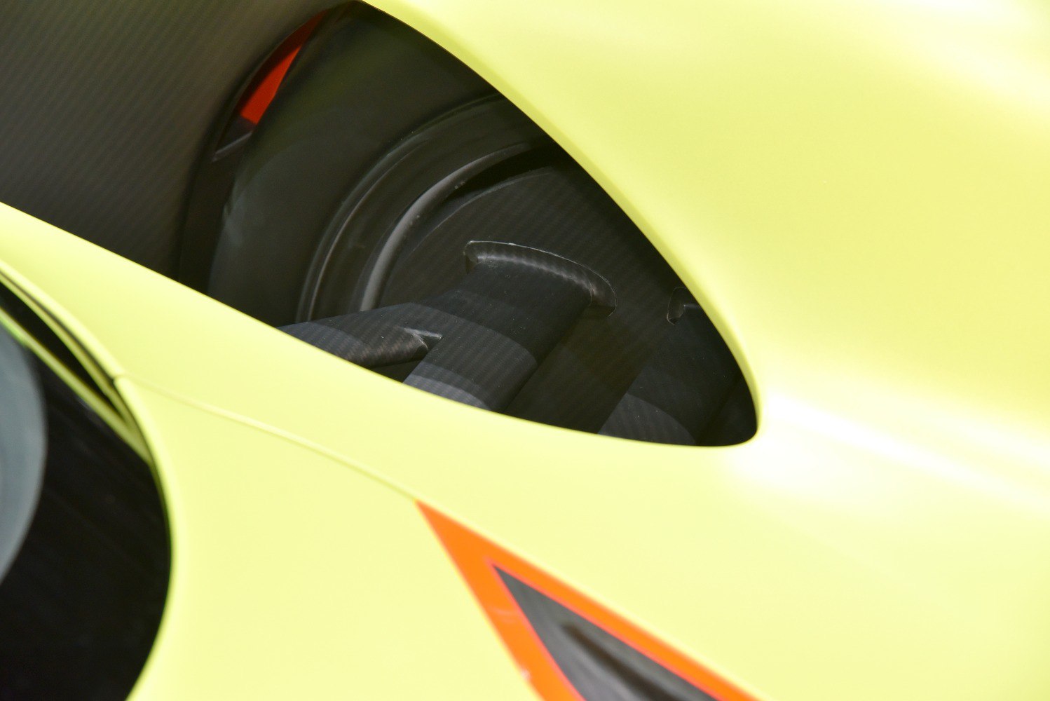 Close-up of carbon fiber wheel arch and aerodynamic element on yellow body
