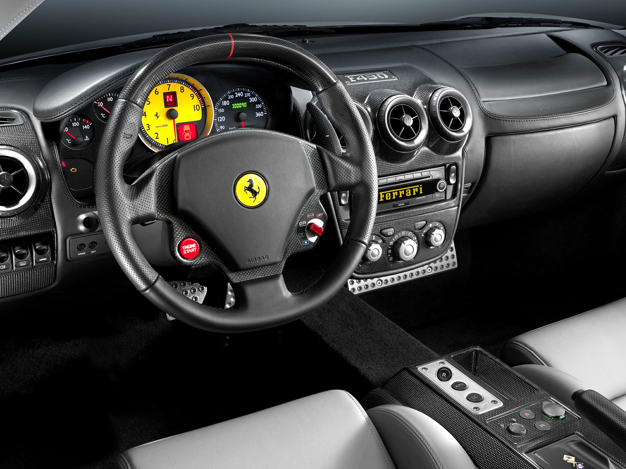 Carbon fiber steering wheel and yellow tachometer in luxury sports car interior