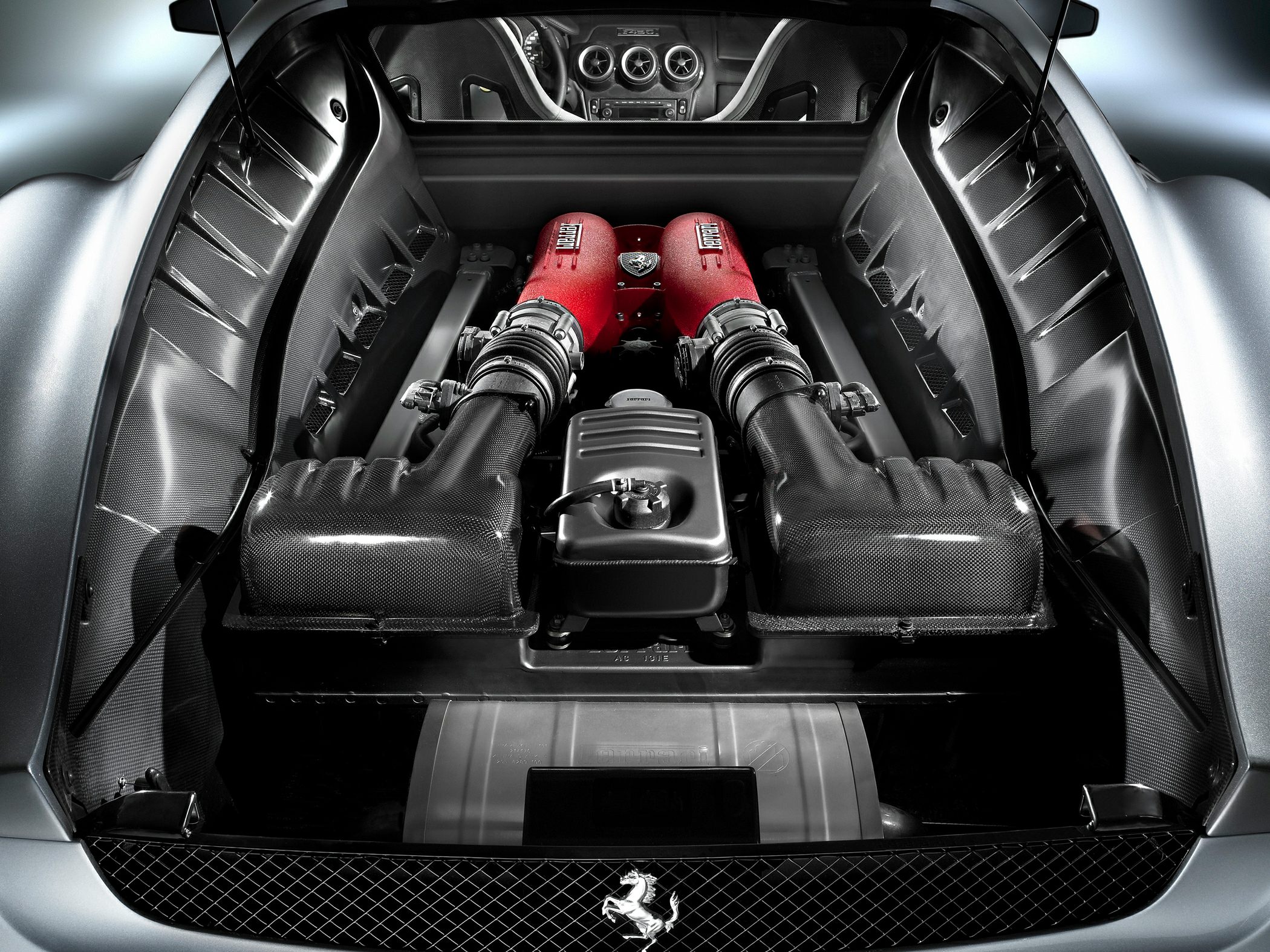 Mid-engine bay with red intake manifolds and carbon fiber components.