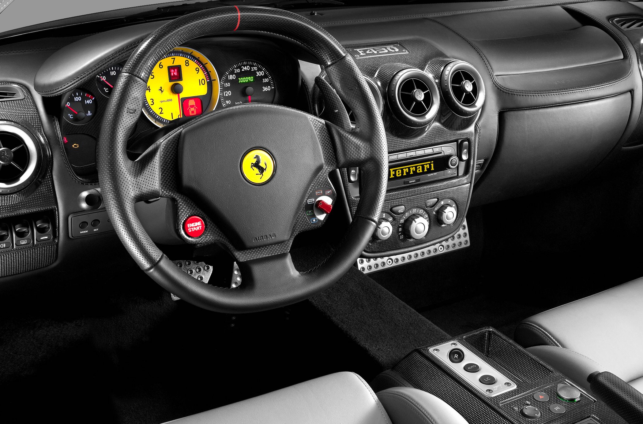 Carbon fiber steering wheel, yellow tachometer, Ferrari dashboard controls
