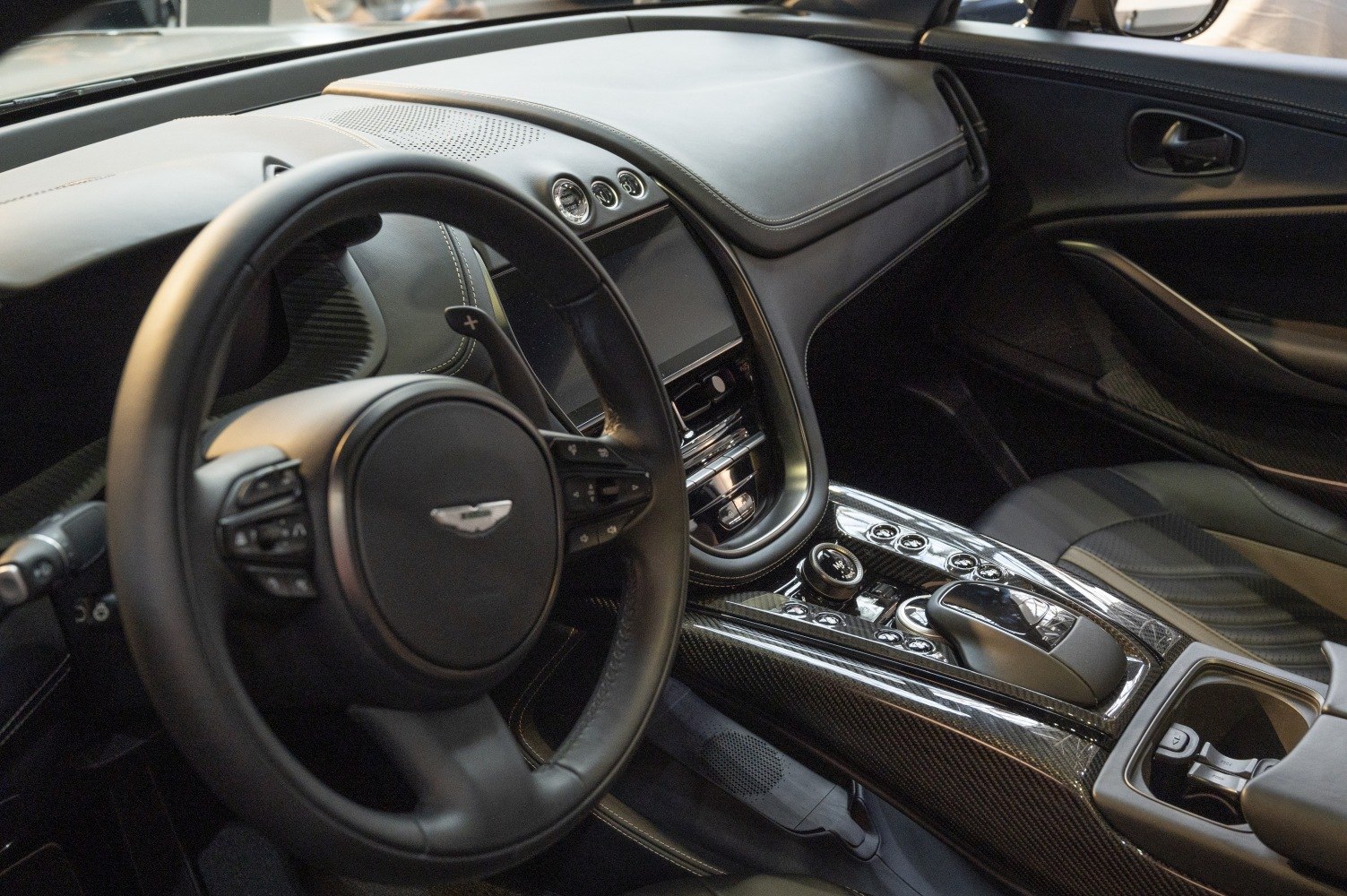 Luxury car interior with steering wheel and carbon fiber center console
