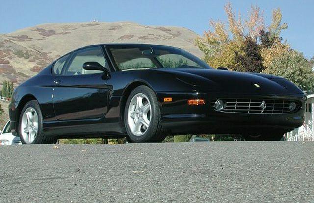Sleek black sports coupe with aerodynamic front side view and alloy wheels