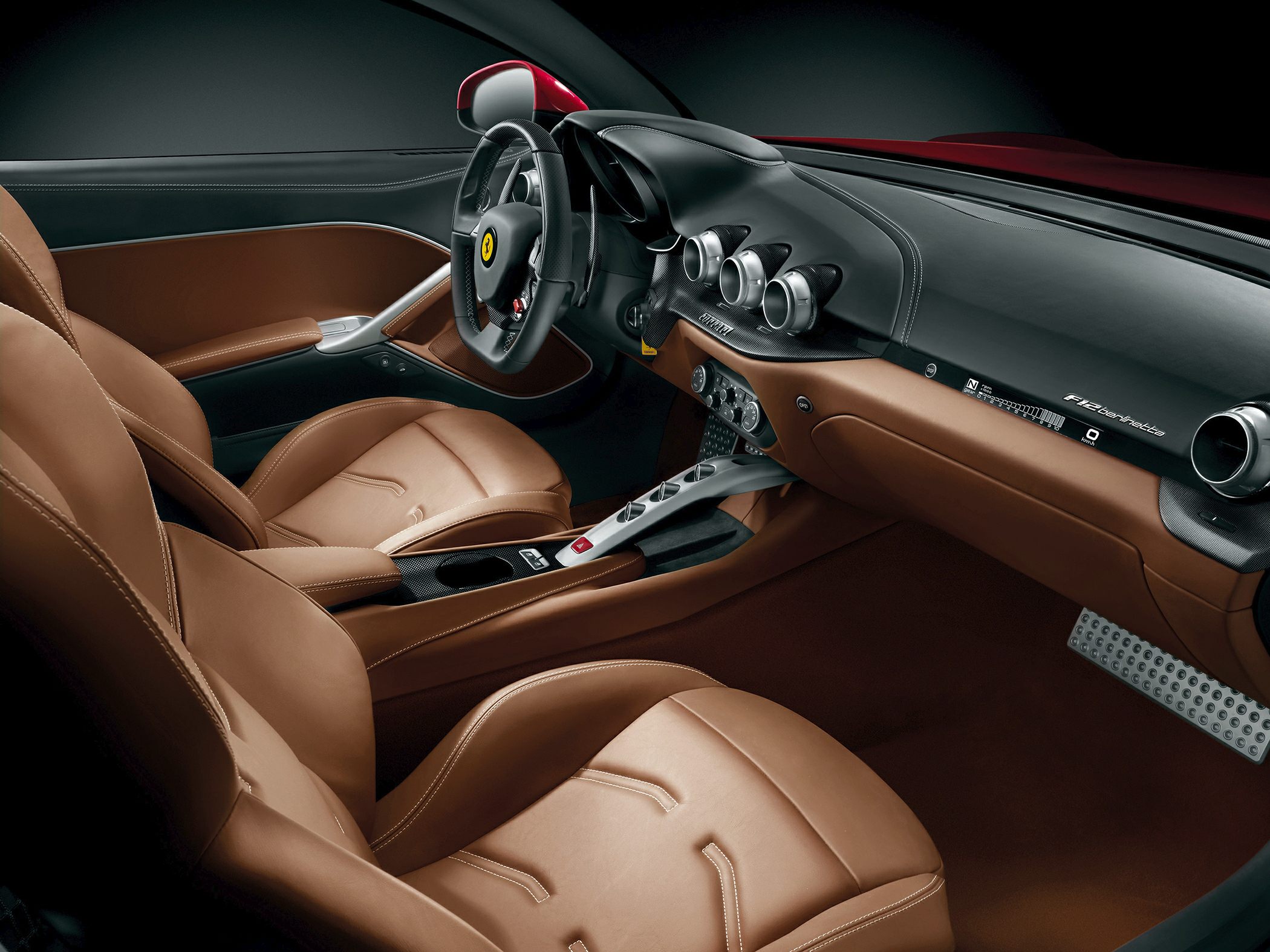 Brown leather seats with modern steering wheel and sleek dashboard featuring unique air vents