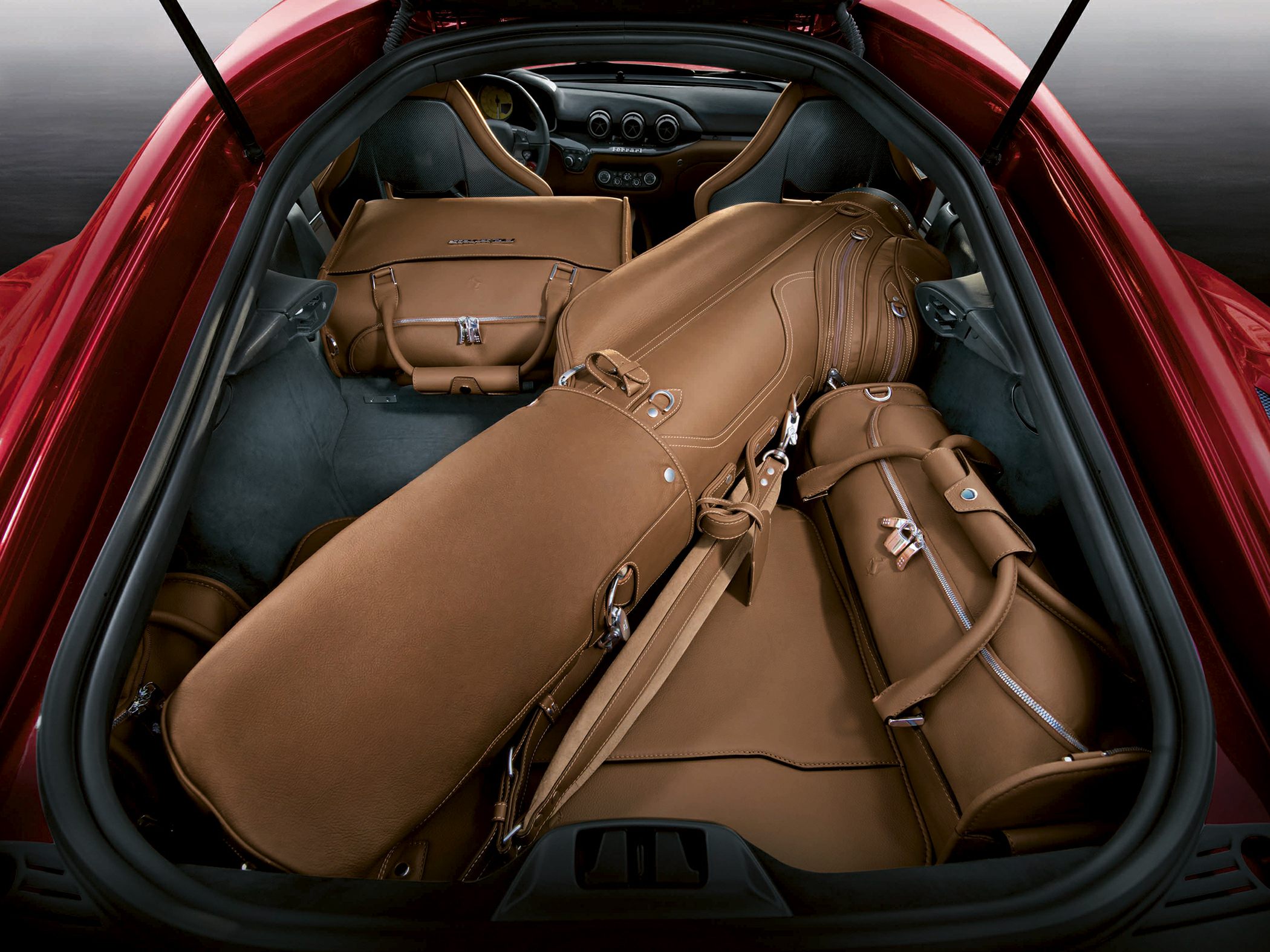 Premium brown leather luggage set fitted in sports car trunk