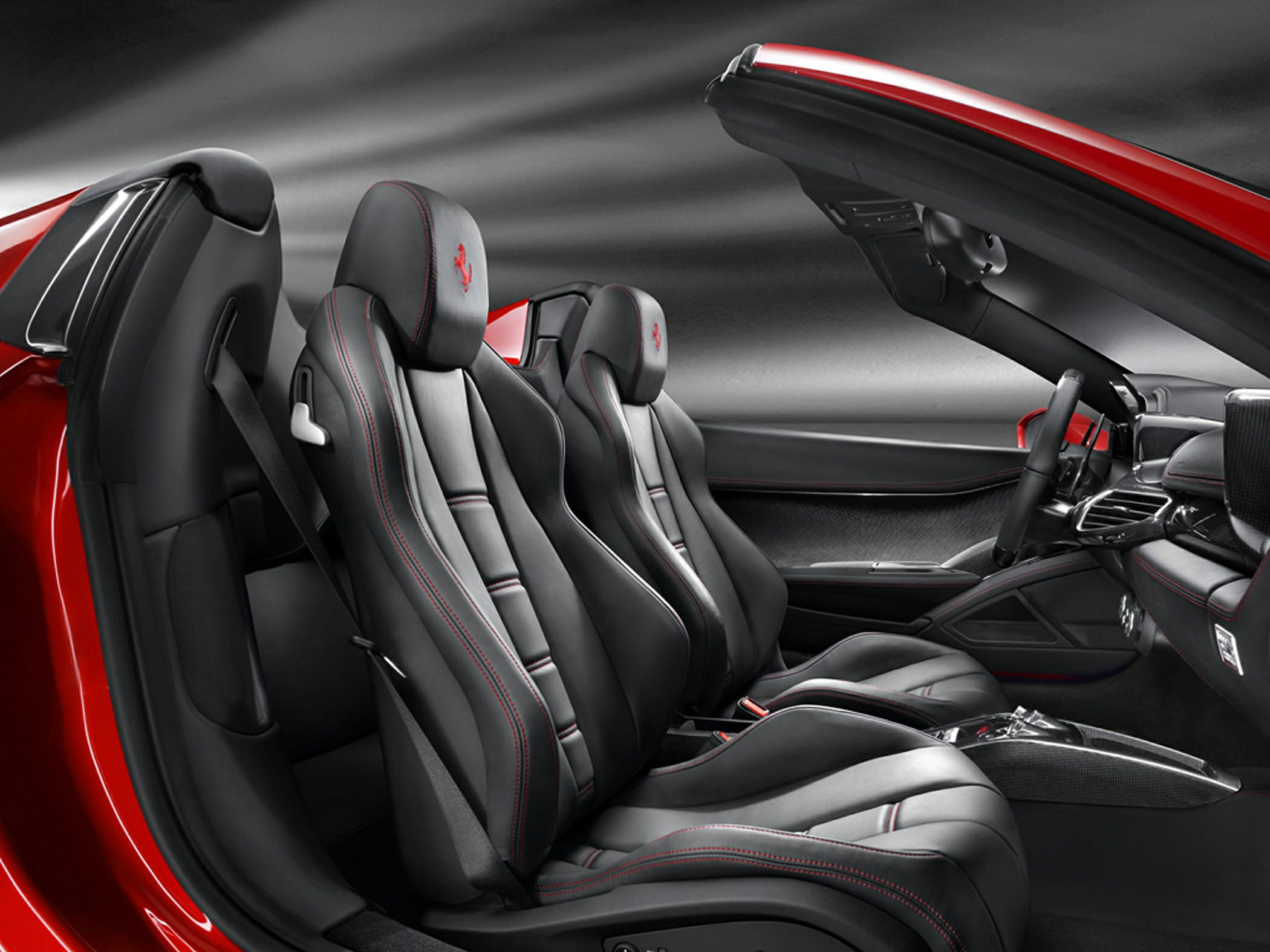 Black leather sport seats with red stitching in convertible cockpit