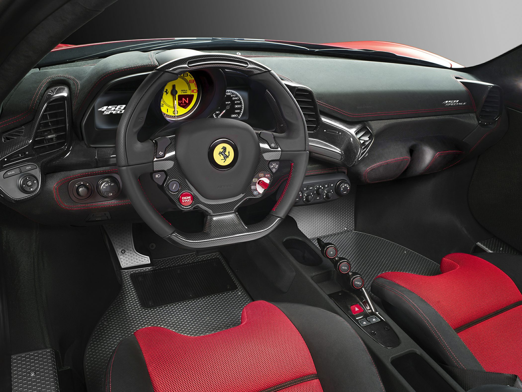 Carbon fiber dashboard with red racing seats and a Ferrari steering wheel.