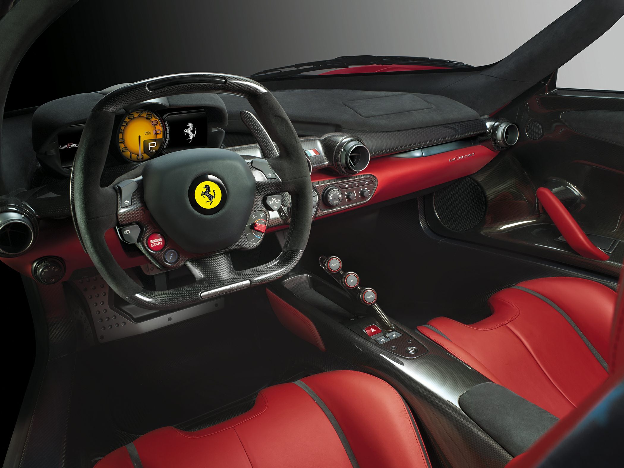 Steering wheel and interior cockpit with red leather seats and carbon fiber accents