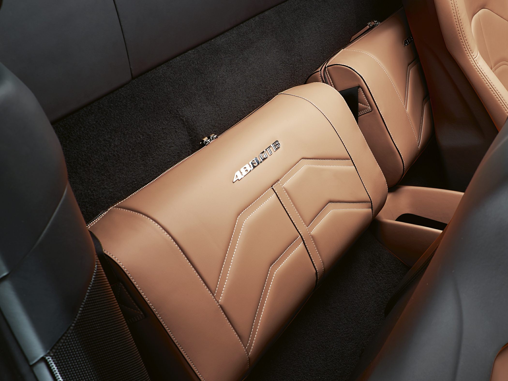 Tan leather luggage with 488 GTB logo and intricate stitched design