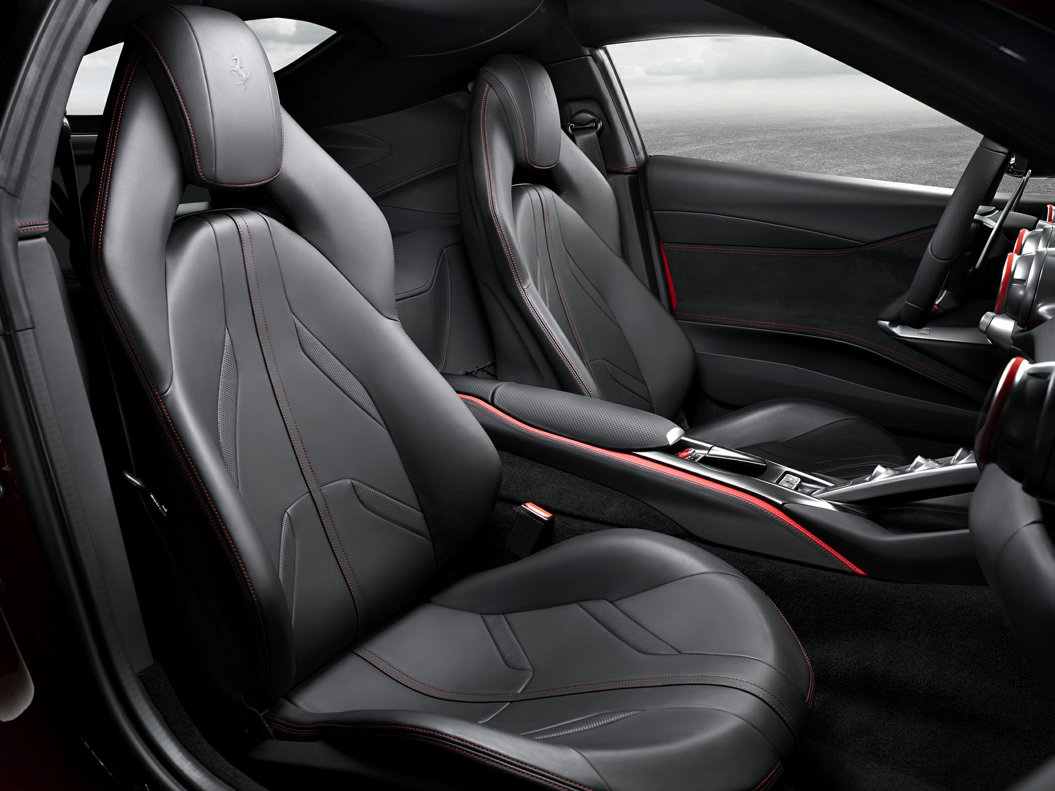 Black leather sport seats with red stitching and ergonomic design.
