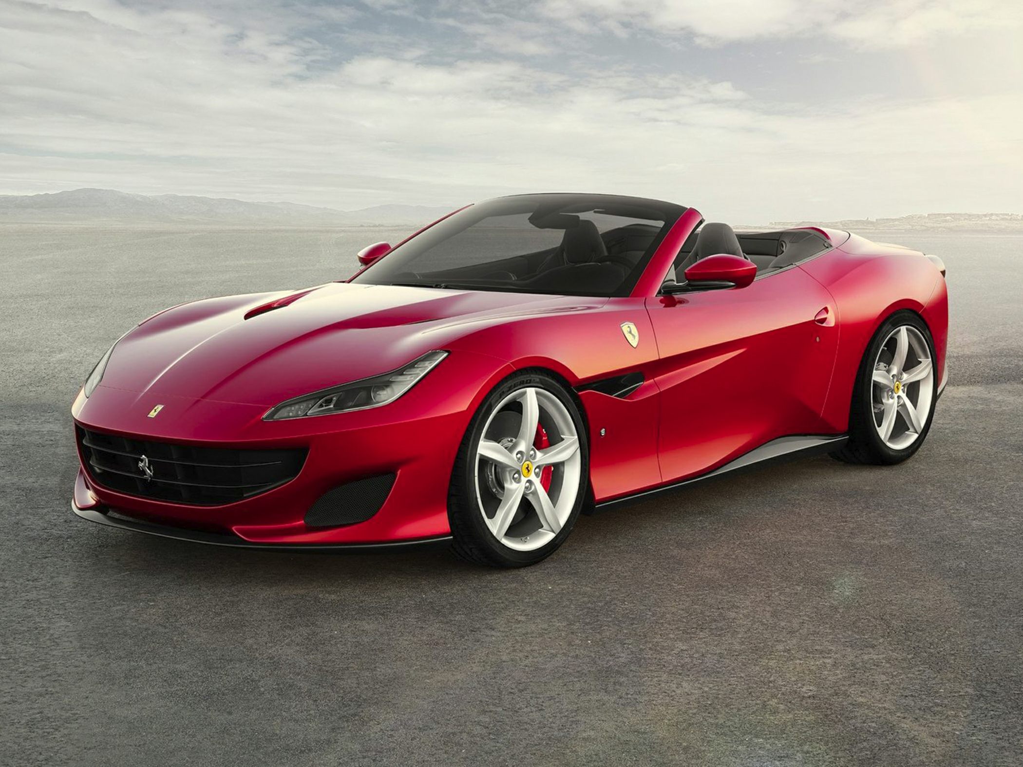 Red convertible sports coupe with aerodynamic hood vents and alloy wheels