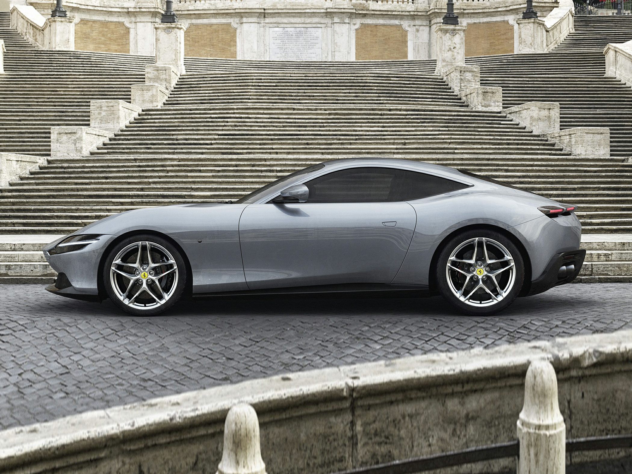 Sleek side profile of matte gray sports coupe with alloy wheels