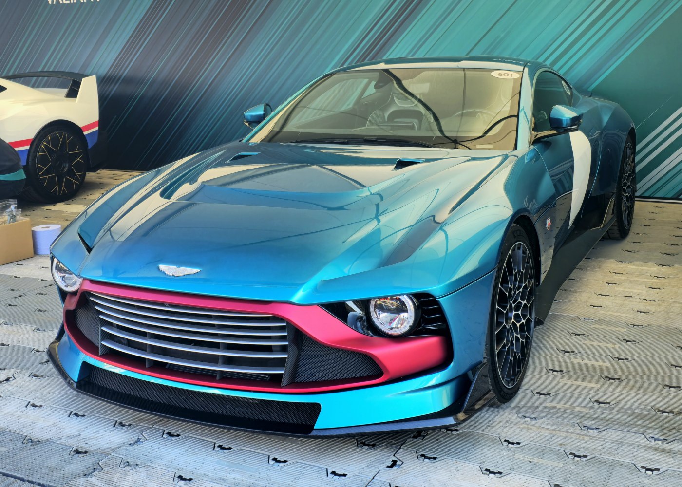 Close-up of front grille and round headlight with aerodynamic hood lines