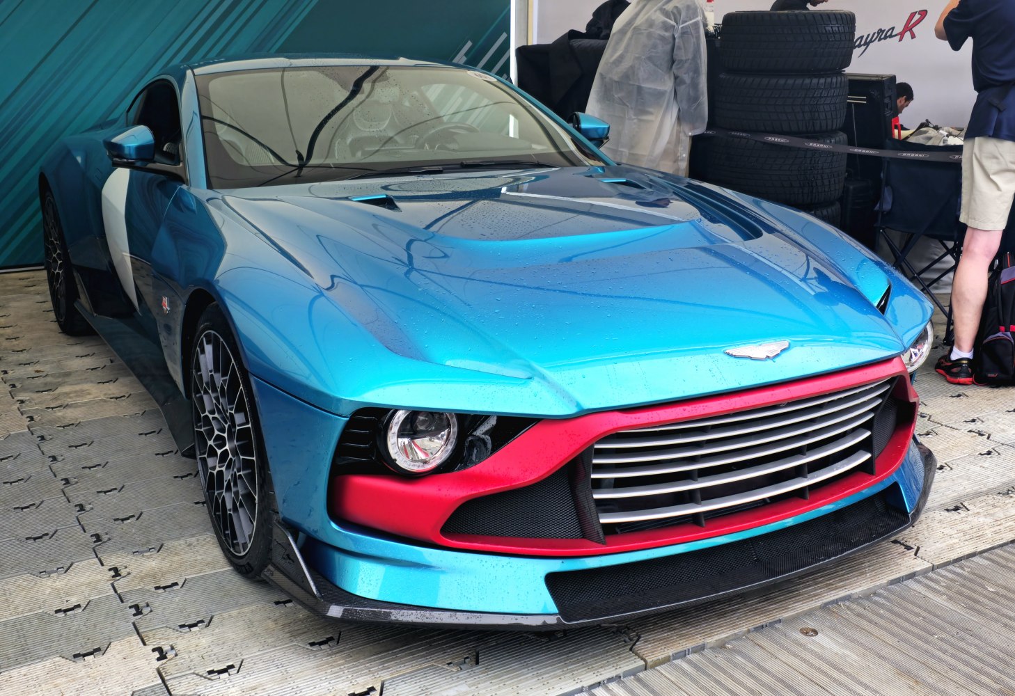 Close-up of front grille and single round headlight with aerodynamic blue body