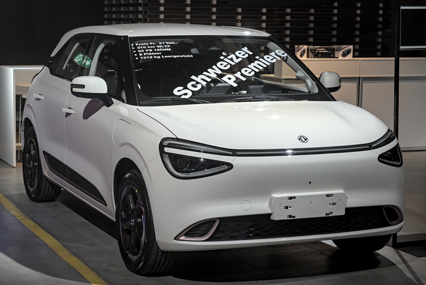 Compact electric vehicle with distinctive headlights and aerodynamic front styling