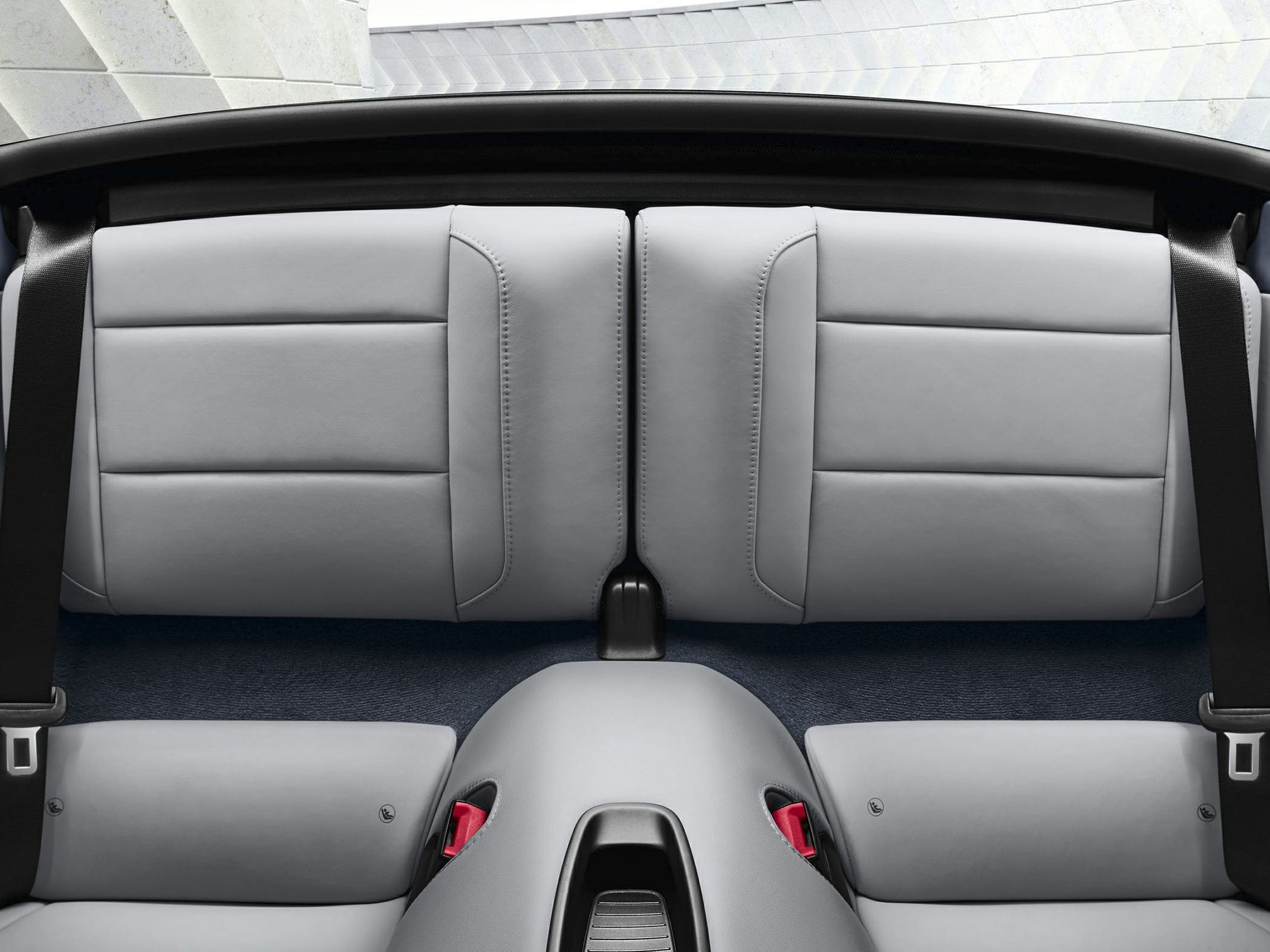 Light gray leather rear seats with seatbelts in a luxury convertible sports car