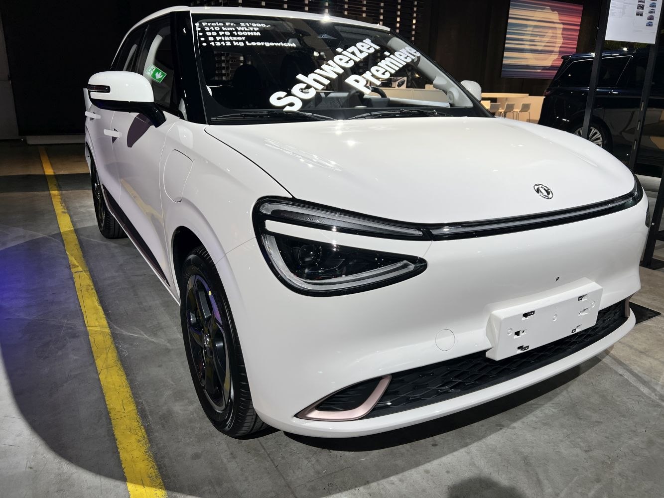 Front view with sleek headlights and minimalist grille of a compact electric vehicle.