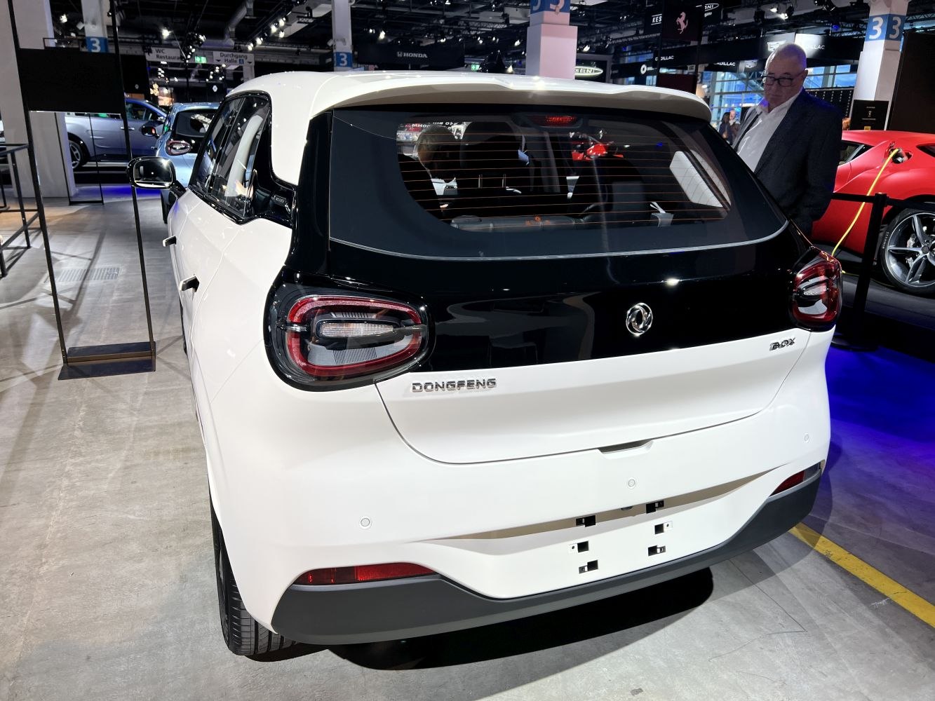 Rear view of a compact hatchback with distinctive taillights and two-tone black and white rear fascia.