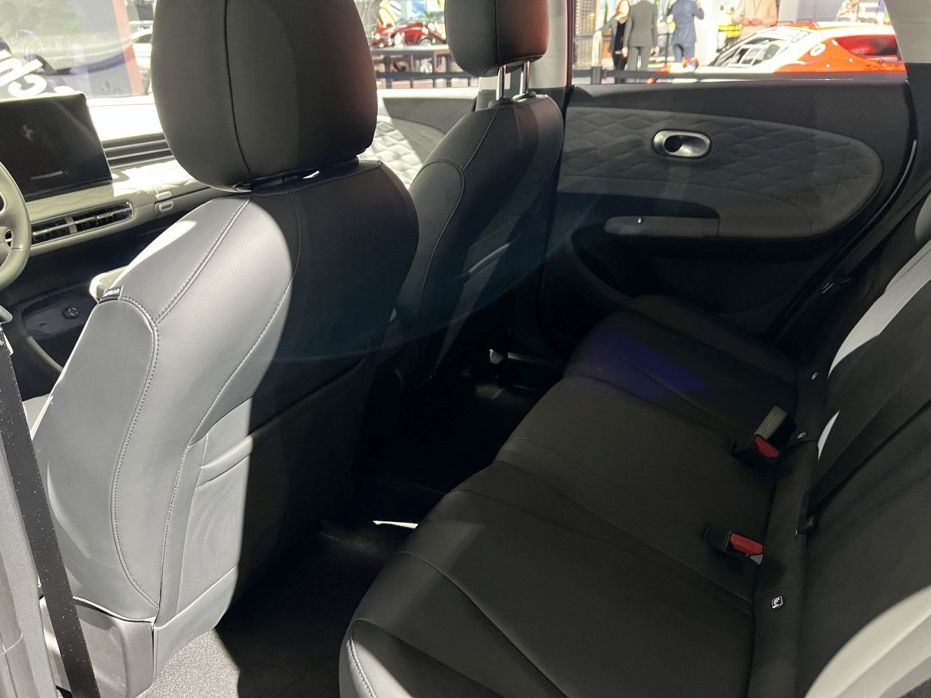 Rear seating area with black upholstery, headrests, and detailed door panels