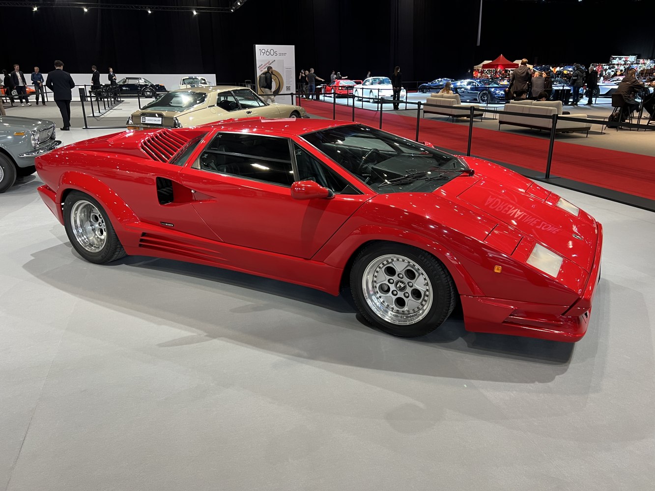 Angular red mid-engine sports car with pop-up headlights and side air intakes.