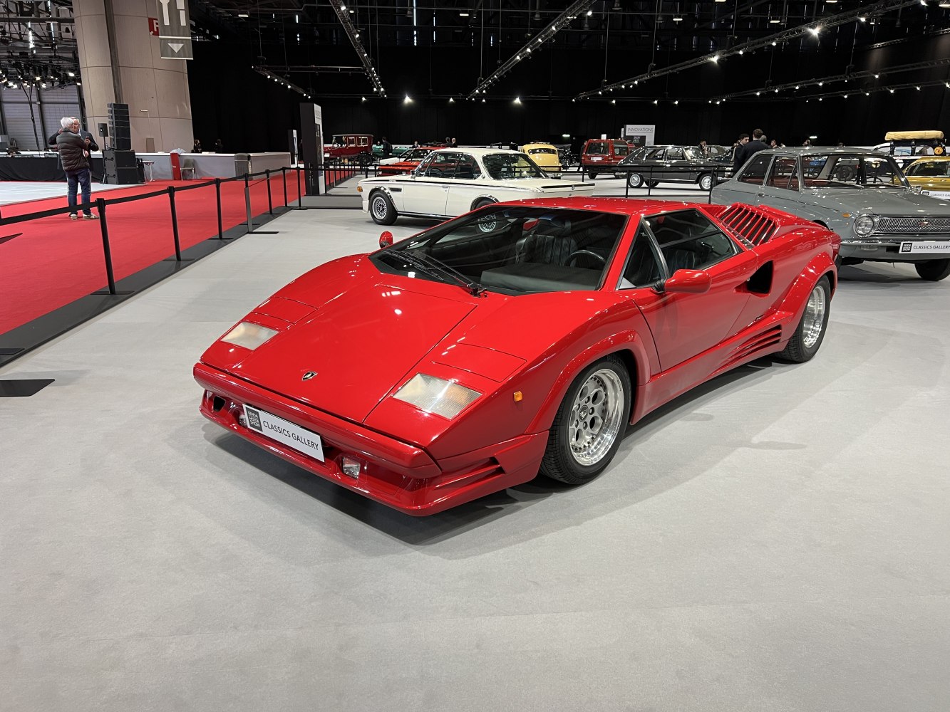 Red sports car with angular body, pop-up headlights, and wide rear air intakes
